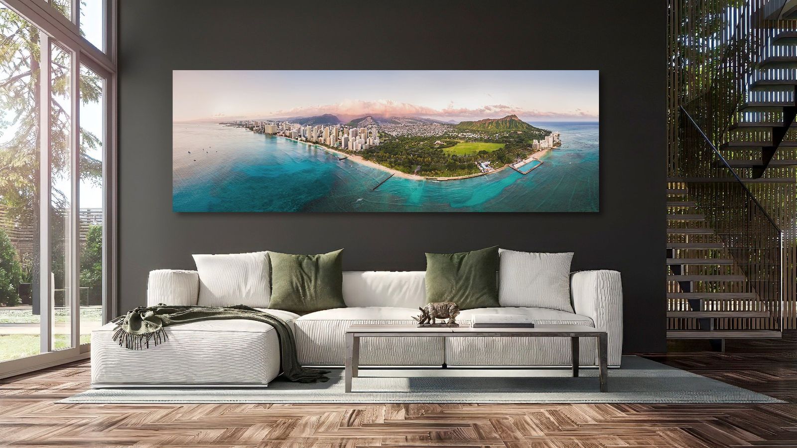 Nani Waikīkī, a 72 by 24 inch panoramic print of Waikīkī and Diamond Head, hanging above a white sofa in a living room with a charcoal wall